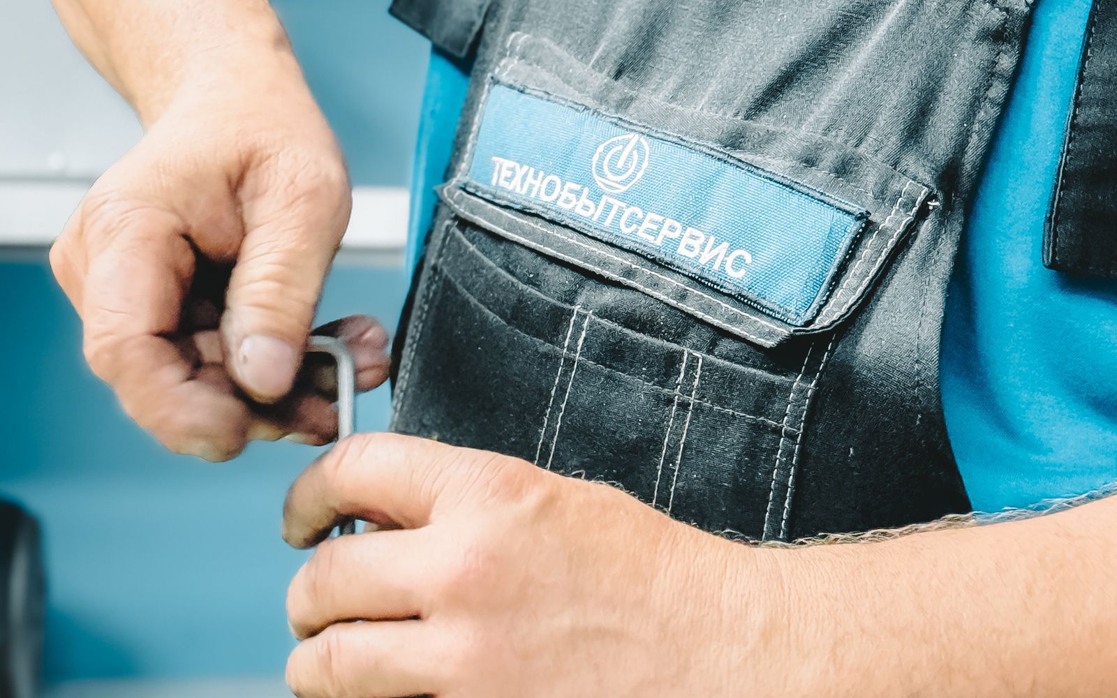 A plumber using a wrench to repair a leaking section of copper pipe