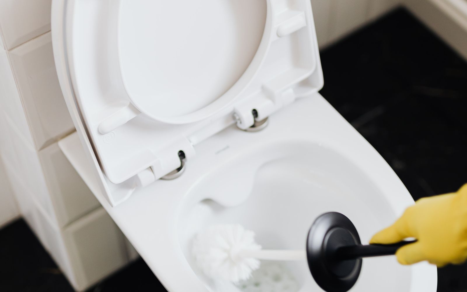 Plumber servicing a toilet tank